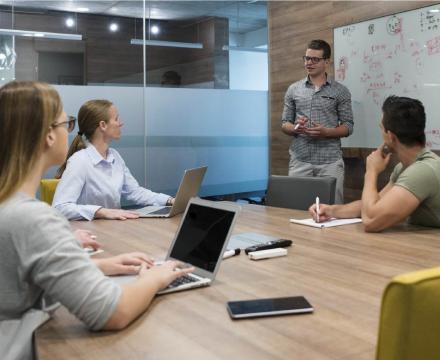 Une équipe de jeunes entrepreneurs brainstorme sur leurs tablettes et ordinateurs portables Une équipe de jeunes entrepreneurs brainstorme sur leurs tablettes et ordinateurs portables